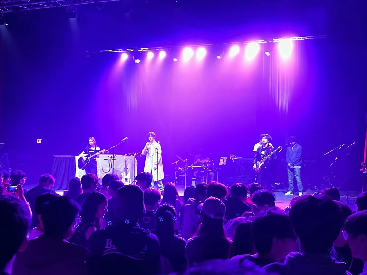 Band performing under purple stage lighting