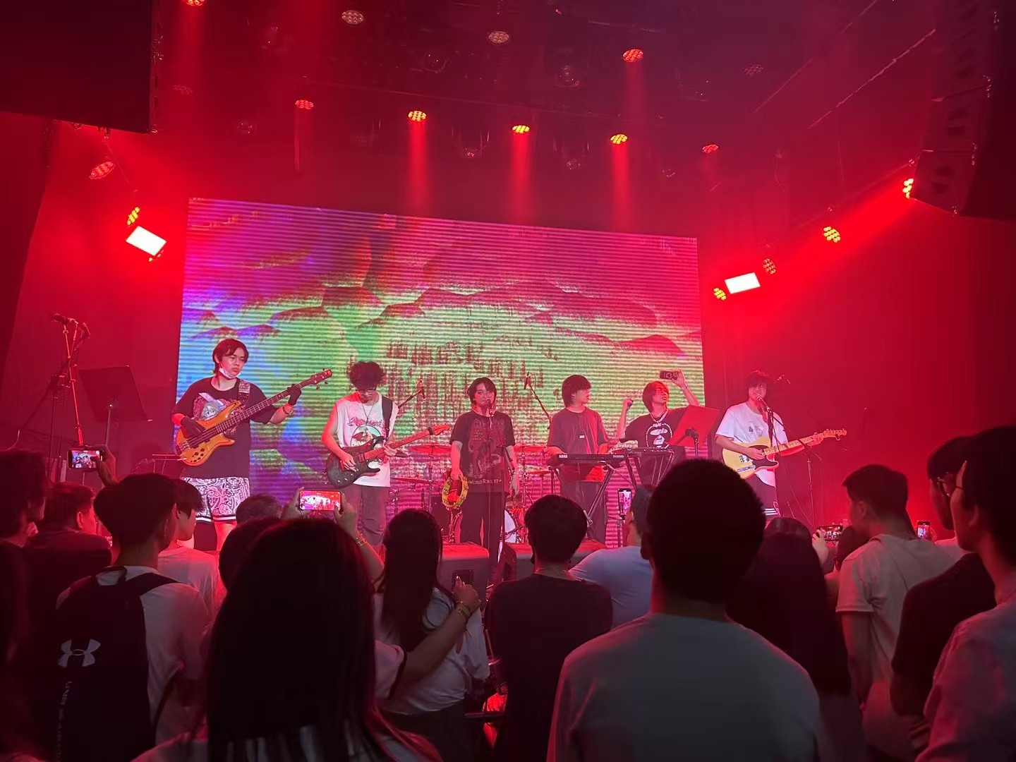 Band performing under red stage lighting